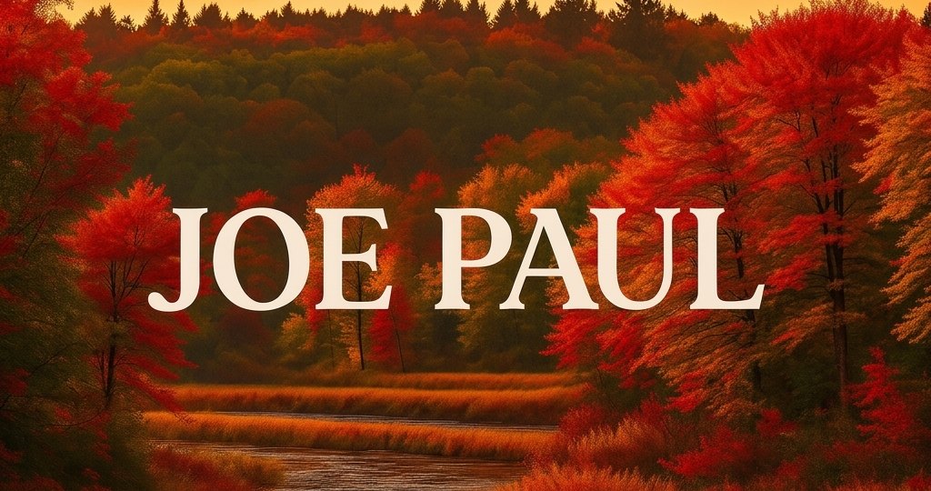 Joe Paul, over a river running through red autumn woods